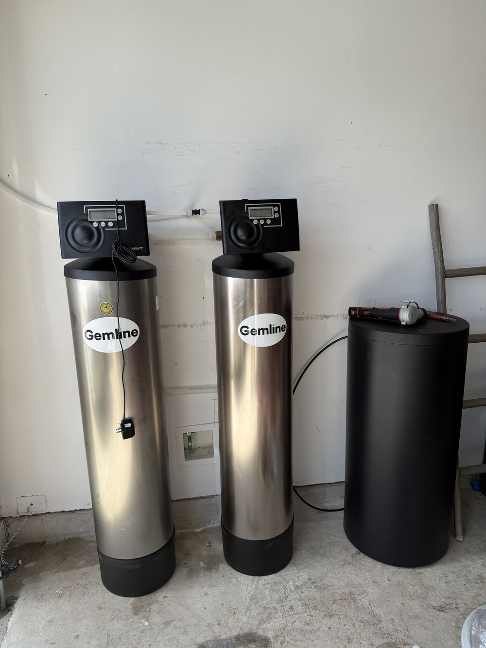 Twin water softener tanks installed in a Katy garage